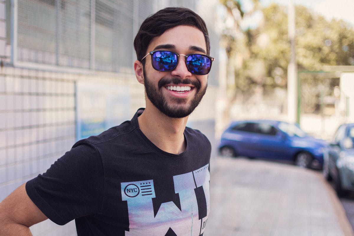 Hombre joven usando lentes de sol con estilo en la ciudad